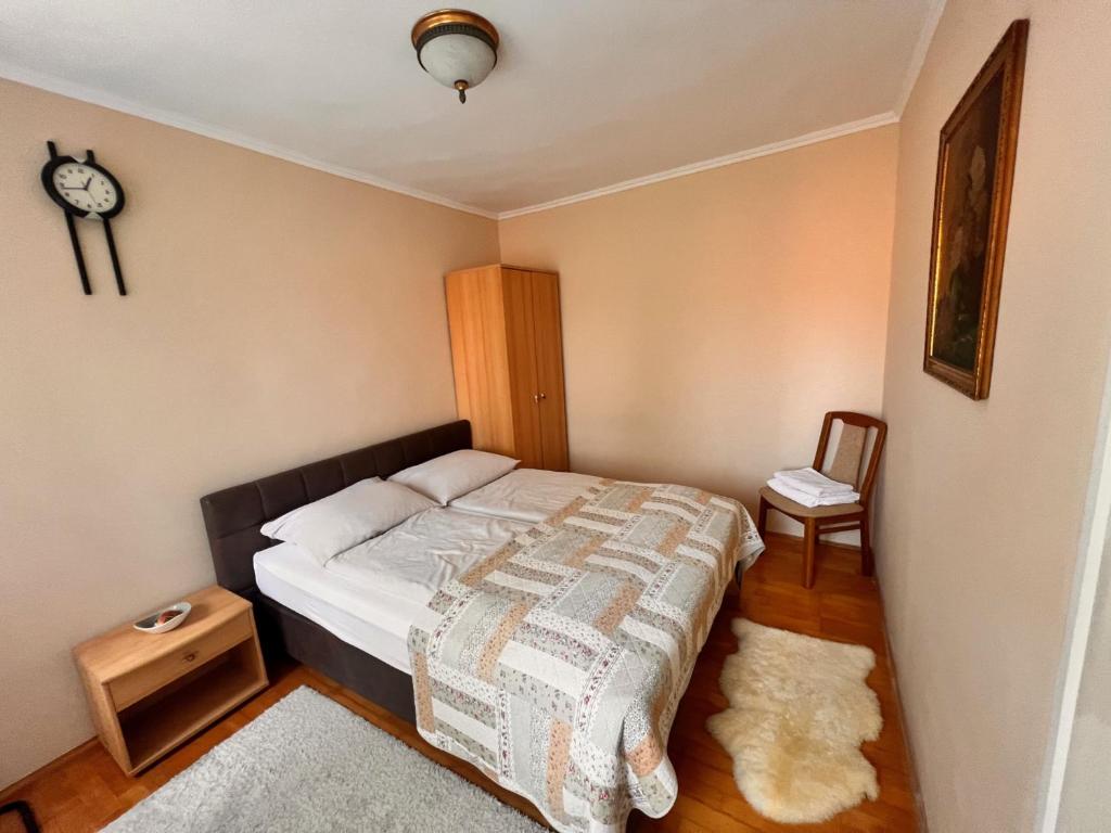 een slaapkamer met een bed en een klok aan de muur bij Bem Apartman in Gyenesdiás