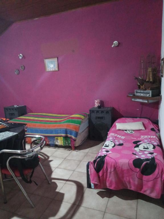 1 dormitorio con paredes rosas y 1 cama en una habitación en Hostel Monte Grande en Monte Grande
