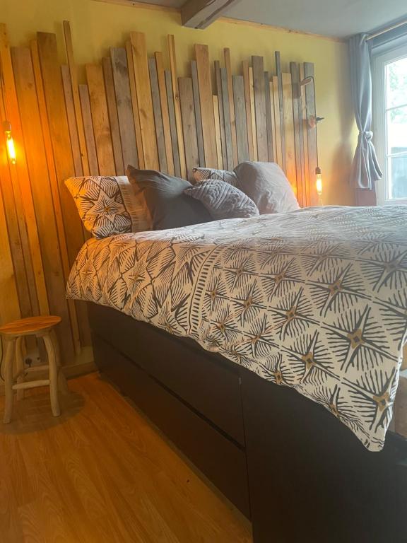 a bedroom with a bed with a wooden headboard at au 39 in Jalhay