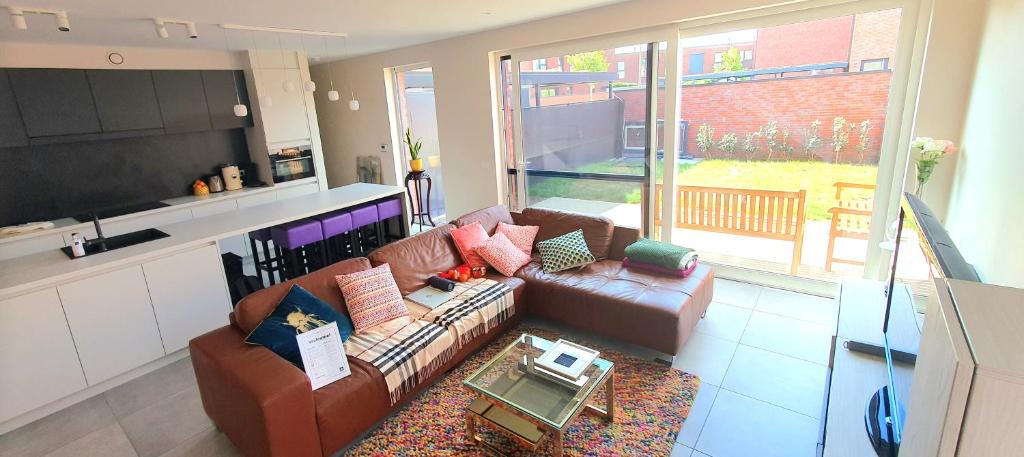 ein Wohnzimmer mit einem Sofa und einem Tisch in der Unterkunft Mooi vakantiehuis tussen Breda, Antwerpen, Gent & Hasselt in Antwerpen