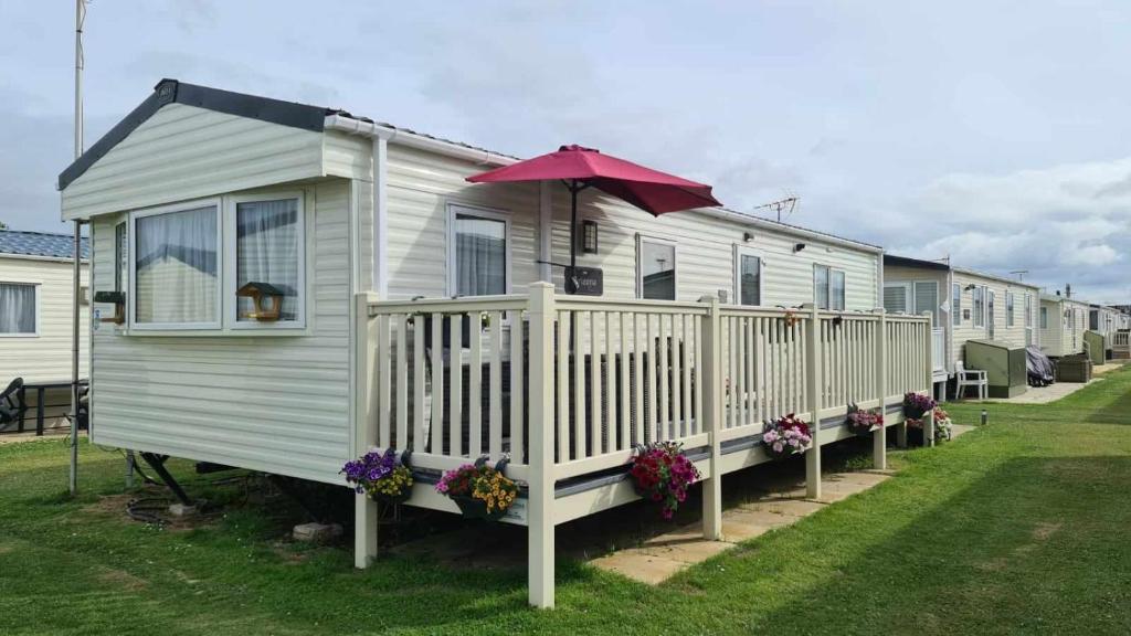 a tiny house with an umbrella on the side of it at Casa Oliphaunt in Kent