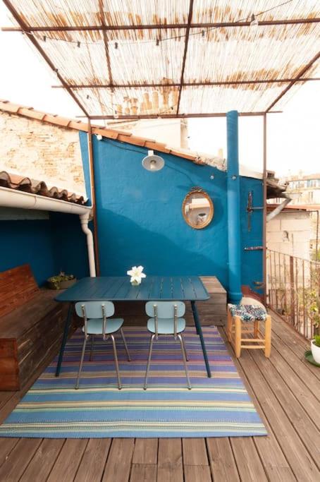 une table bleue et deux chaises sur une terrasse dans l'établissement Magnifique Duplex proche cours Julien, à Marseille