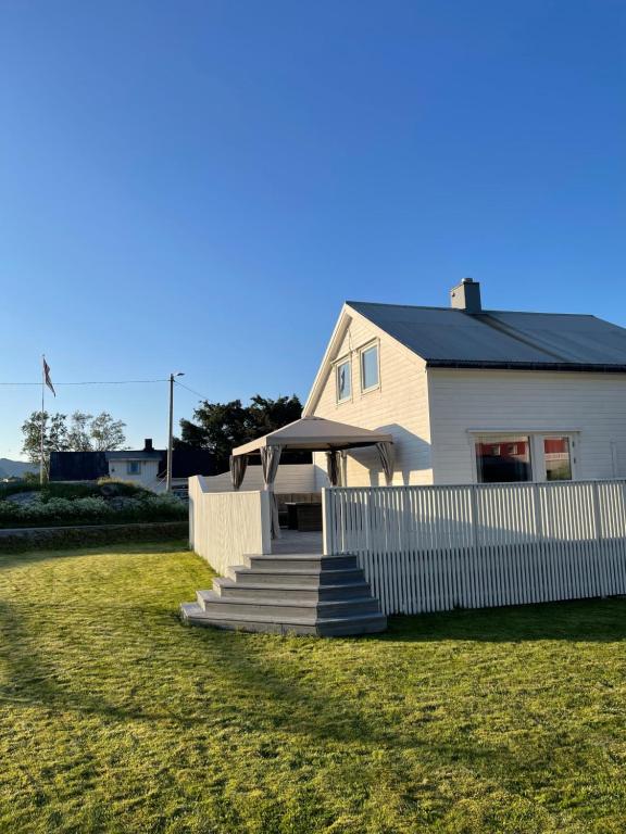 a white house with a white fence and stairs at Et koselig hus i vakre Lofoten in Stamsund