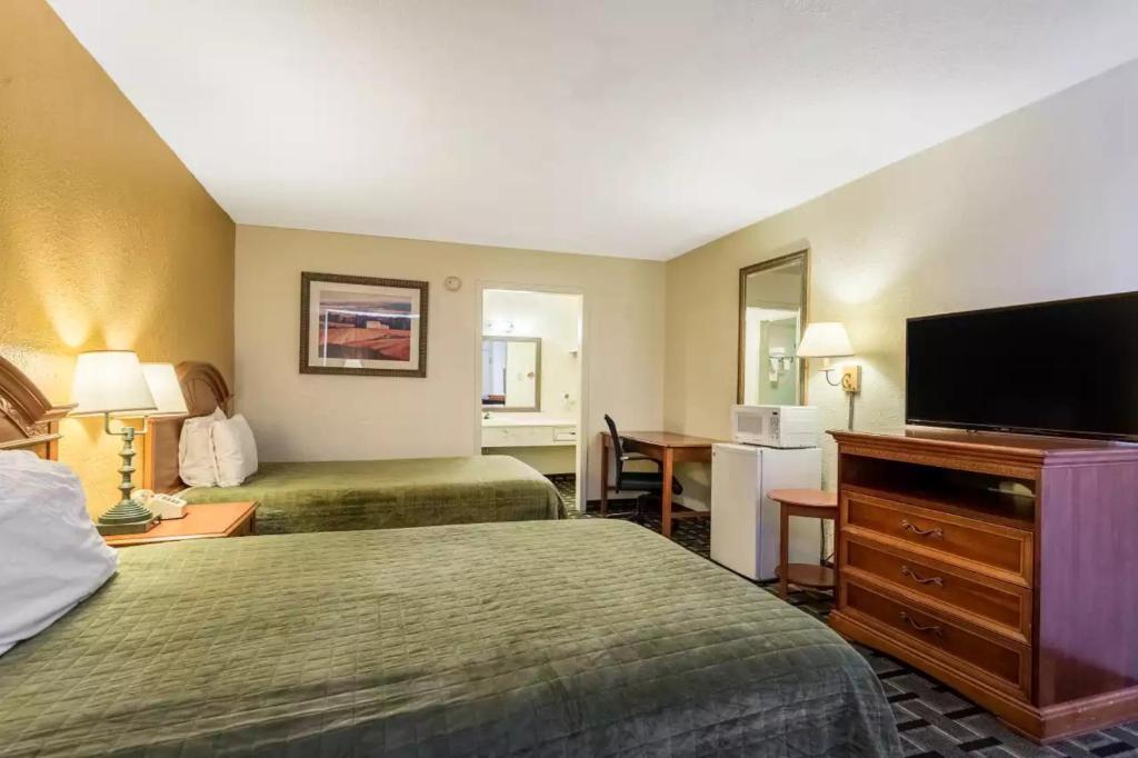 a hotel room with two beds and a flat screen tv at Rodeway Inn Denmark-Jackson in Denmark
