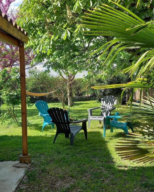 a group of chairs sitting in the grass at L'écrin de Louise in Barry-dʼIslemade