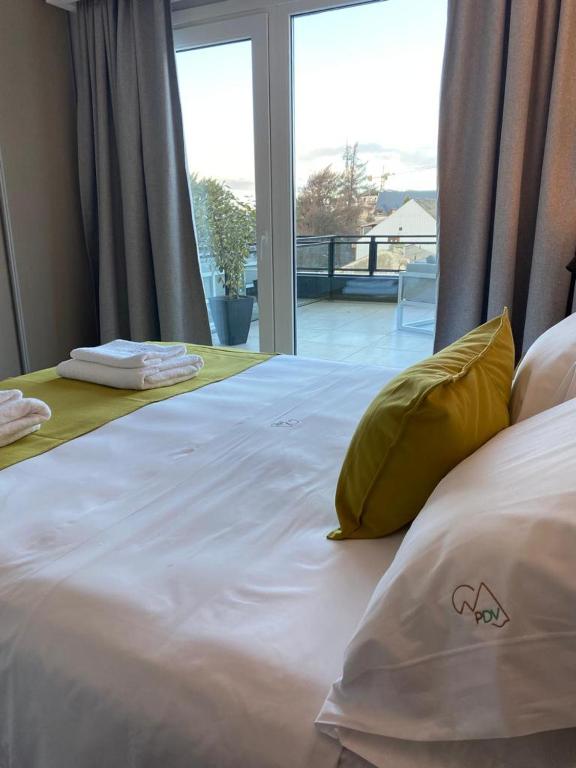a large white bed with yellow pillows and a window at Patagonia Deluxe View in San Carlos de Bariloche