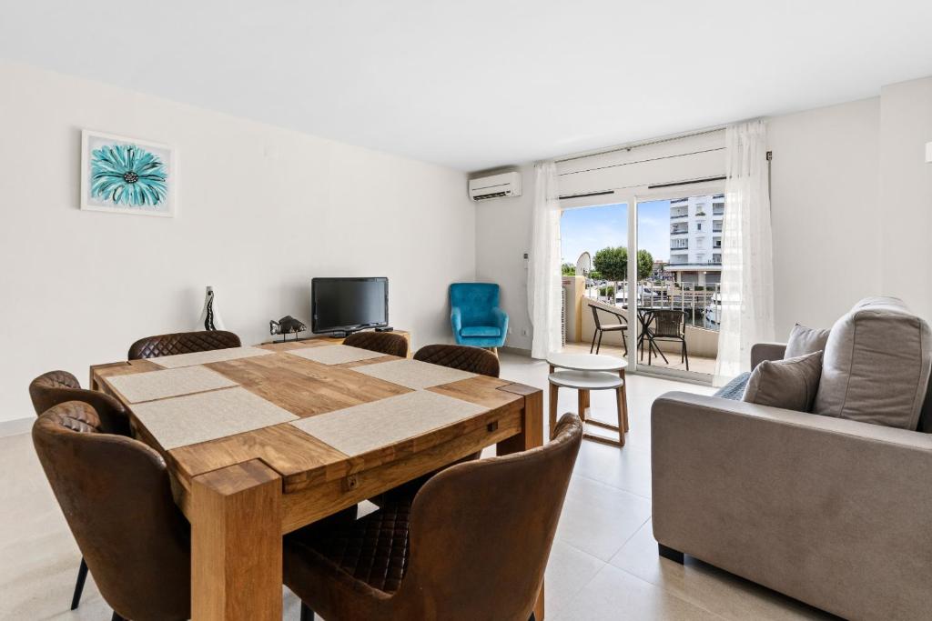 a living room with a wooden table and a couch at Apartamento WELCS EMP 093 con vistas al Canal in Empuriabrava