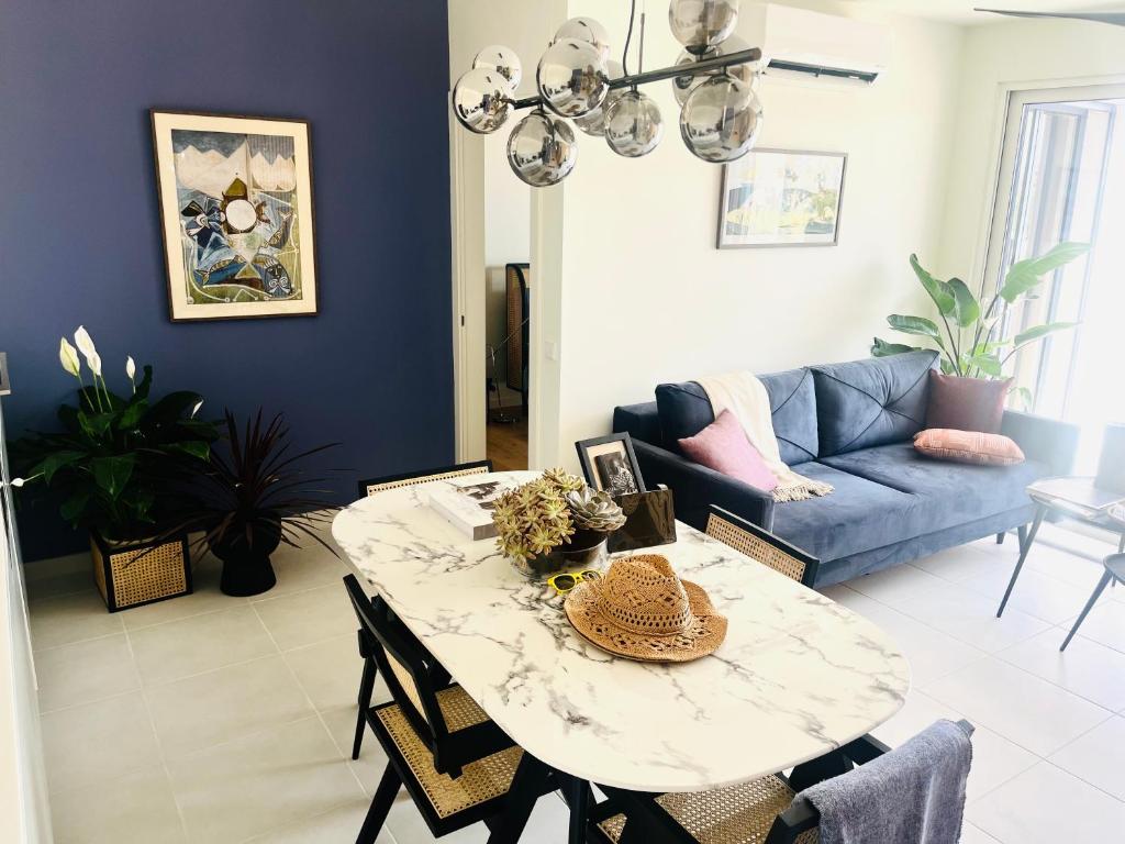 a living room with a table and a blue couch at Picasso Apartament in Tavira