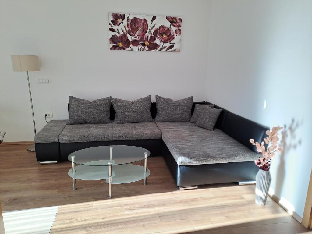 a living room with a couch and a glass table at Yulia Apartman in Pula