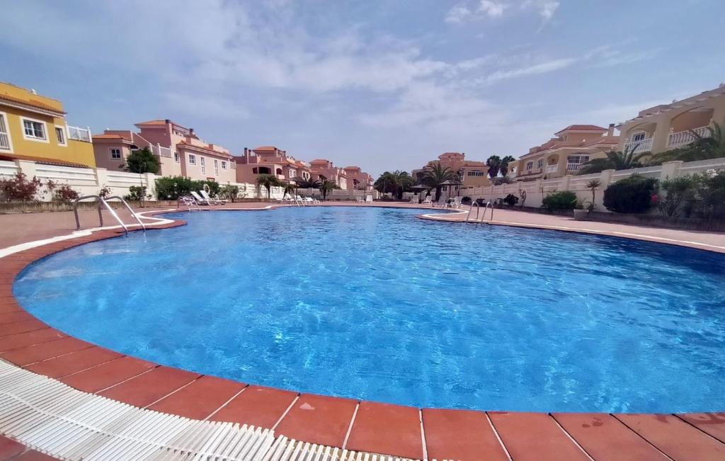 a large swimming pool with blue water at Casa Atlantica Golf & Sea view in Caleta De Fuste