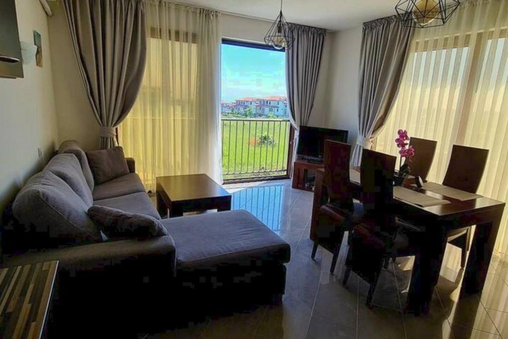 ein Wohnzimmer mit einem Sofa, einem Tisch und einem Fenster in der Unterkunft Villa Dimar 2B in Lozenets