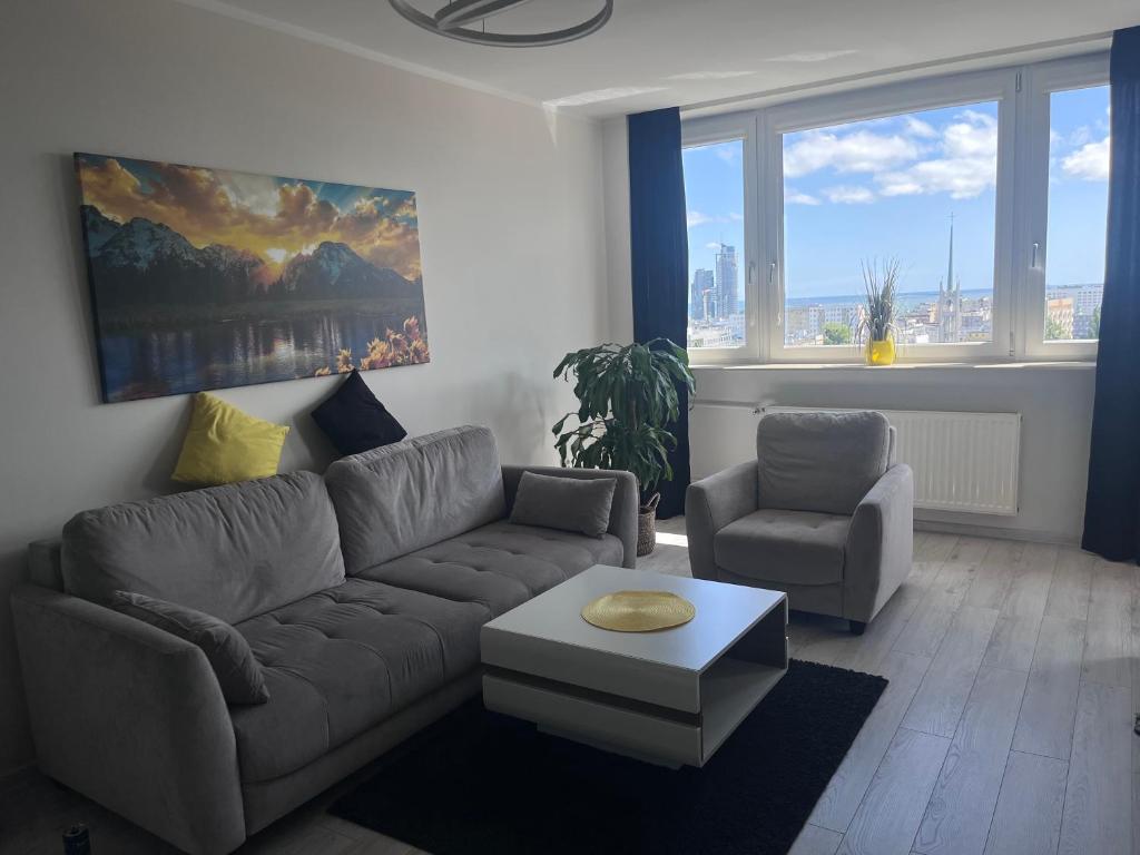 salon z kanapą i krzesłem w obiekcie Apartament z widokiem na morze w mieście Gdynia
