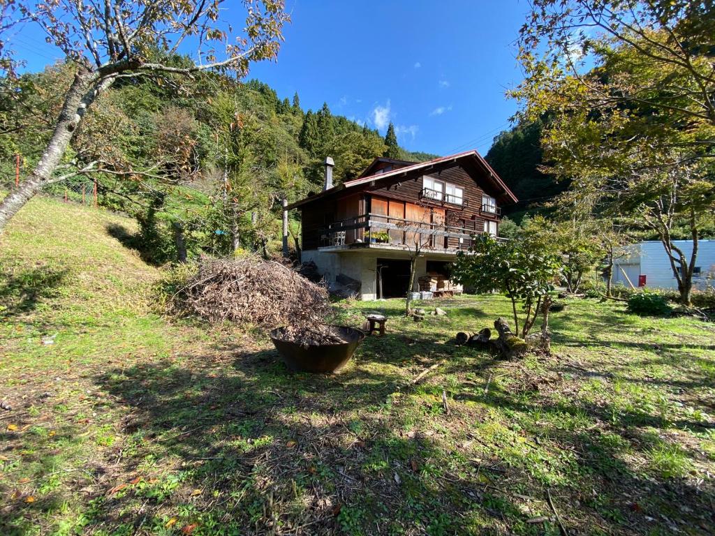 Muraoka的住宿－kakayama hutte，坐落在郁郁葱葱的绿色田野上的房子