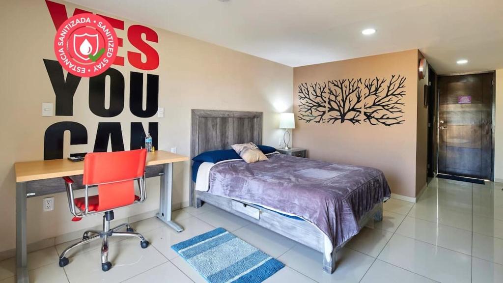 um quarto com uma cama, uma secretária e uma cadeira vermelha em S88 SUPER MINI DEPA HERMOSO!!!! A 5 MIN DEL ITES CEM em Cidade do México
