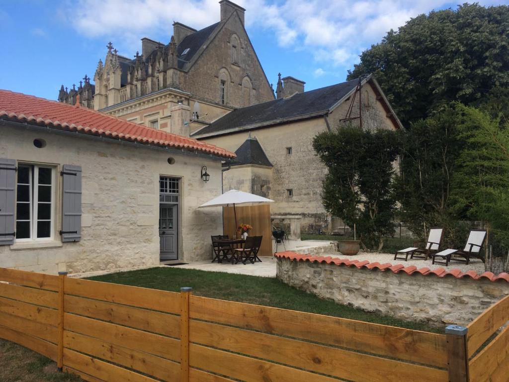 a backyard with a wooden fence and a building at Swallows, Beautiful gite in the grounds of Chateau Beauvoir 