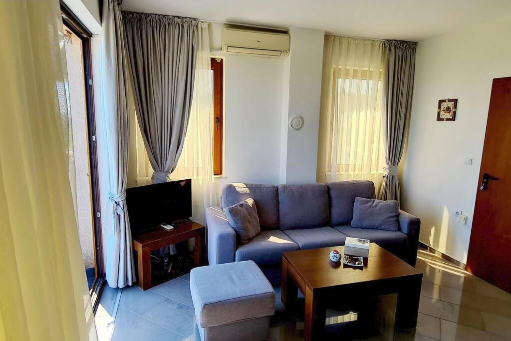 sala de estar con sofá azul y mesa en Seagarden Villa Resort / Villa Dimar 2C, en Lozenets
