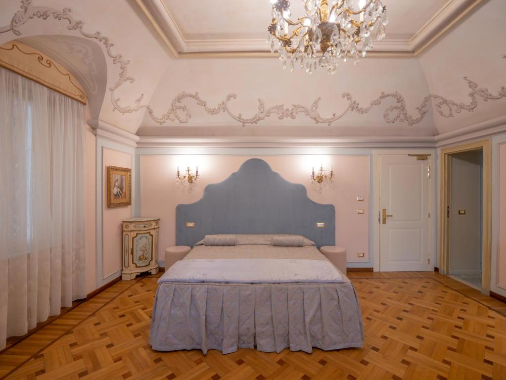 a bedroom with a large bed with a chandelier at Casa Balzola - Suite Incanto in Alassio