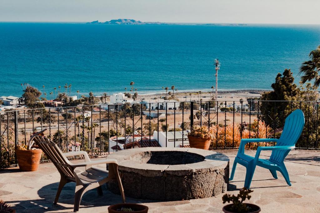 a fire pit with two chairs and a beach at Su Casa in Ensenada