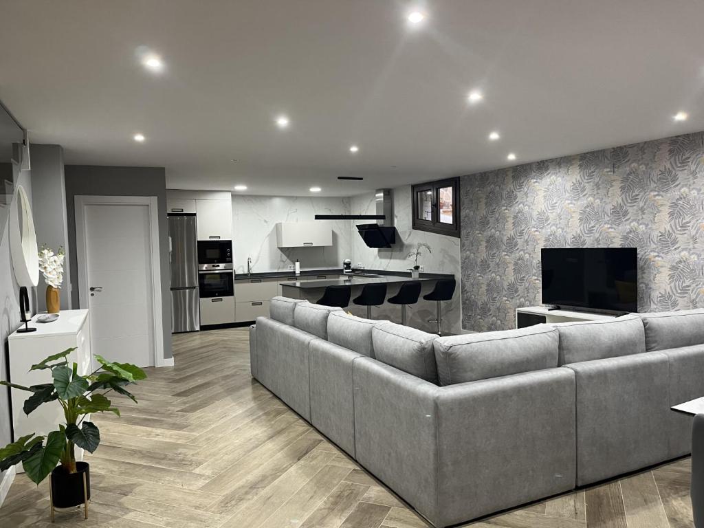 a large living room with a couch and a tv at MIRAGREDOS CASA RURAL in Mombeltrán