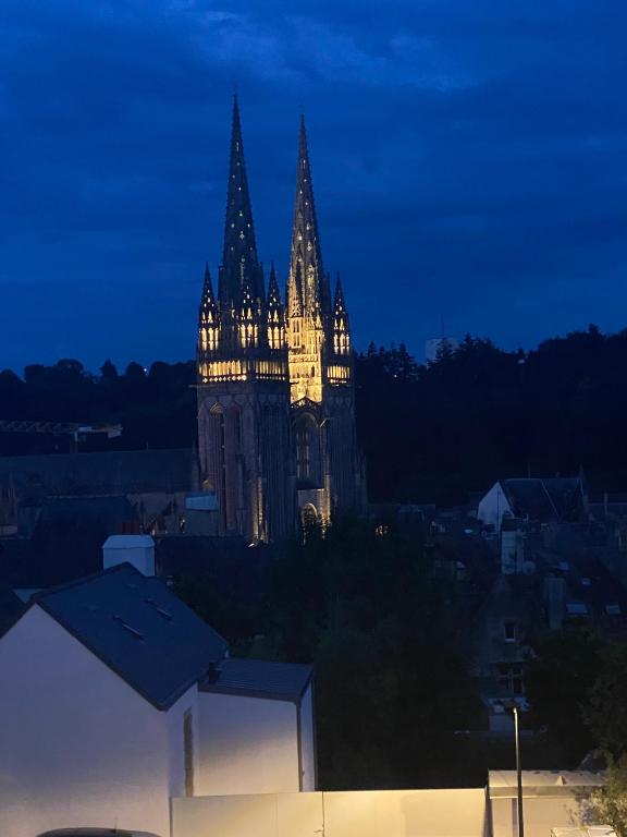 une cathédrale éclairée la nuit dans une ville dans l'établissement Le duplex Saint-Corentin - Hyper Centre - Parking Privé, à Quimper