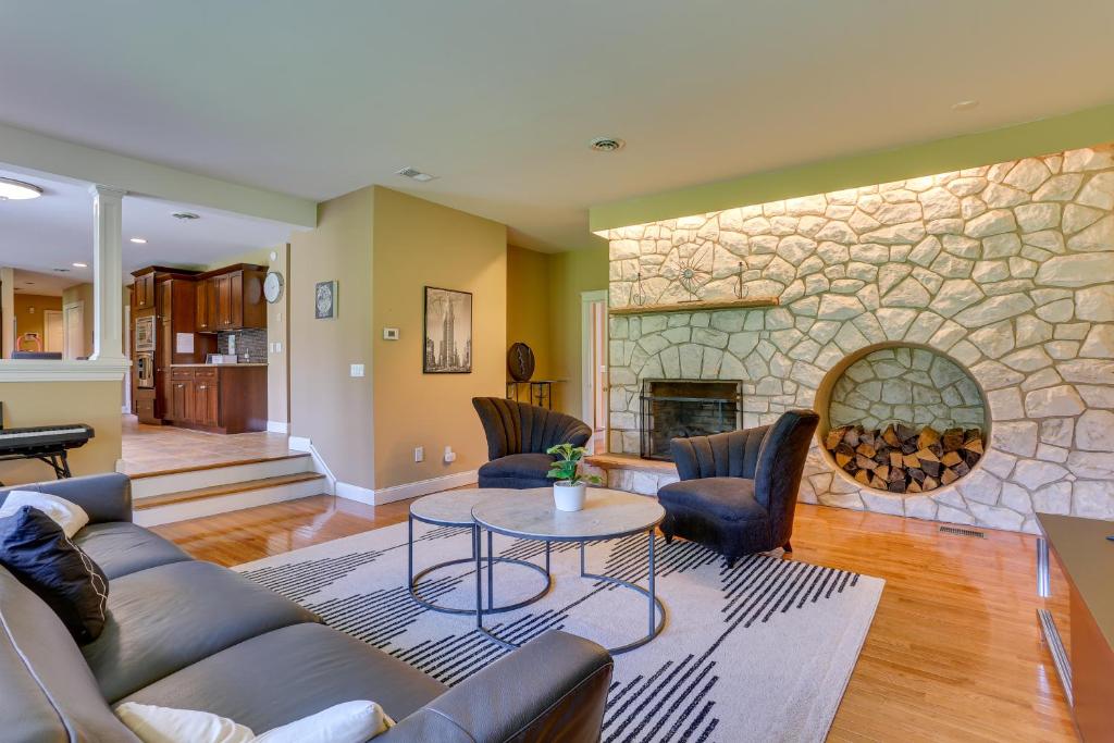 a living room with a couch and a stone fireplace at Warwick Vacation Rental with Private Yard and Fire Pit in Warwick