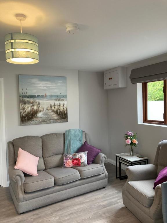 a living room with a couch and a table at Willow Tree Cottage in Ballycastle