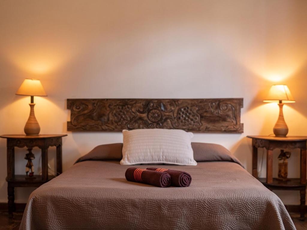 1 dormitorio con 1 cama con 2 lámparas en 2 mesas en Casita Del Escritor, en Antigua Guatemala