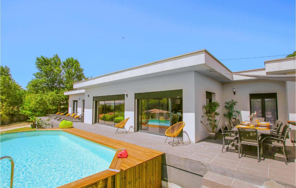 a house with a swimming pool and a table and chairs at Amazing Home In Montlimar With Outdoor Swimming Pool in Montélimar