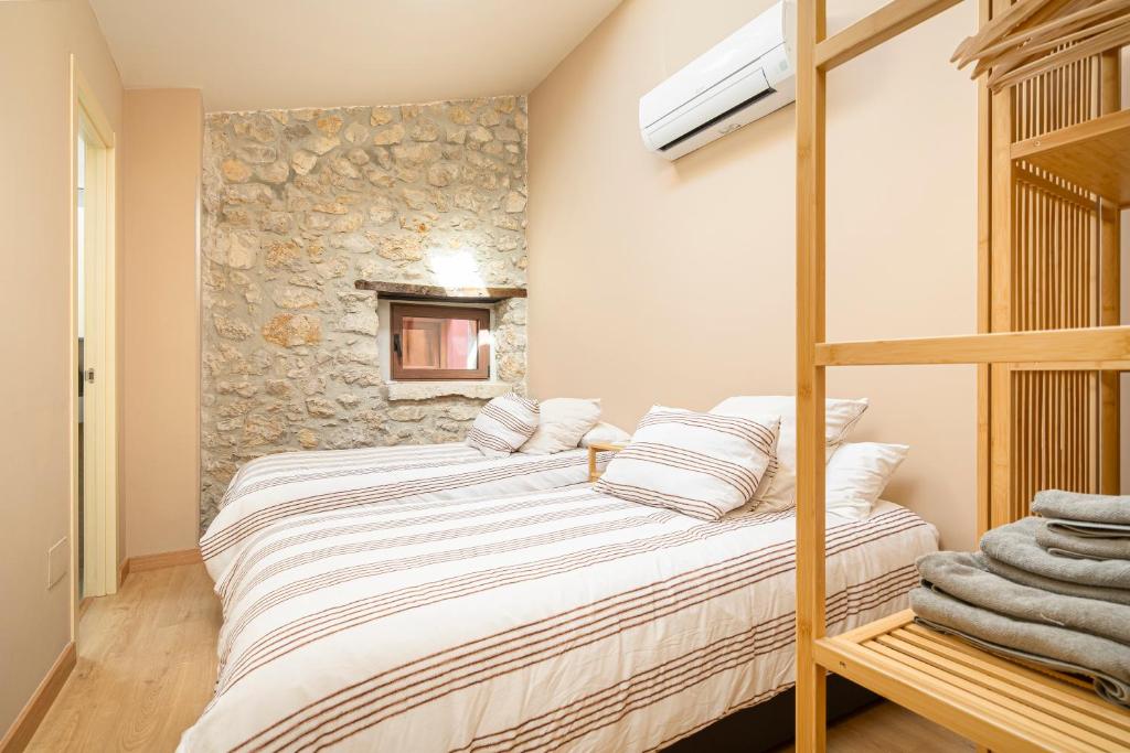 a bedroom with a bunk bed and a stone wall at Apartamentos Calle Mayor 23 Llanes in Llanes
