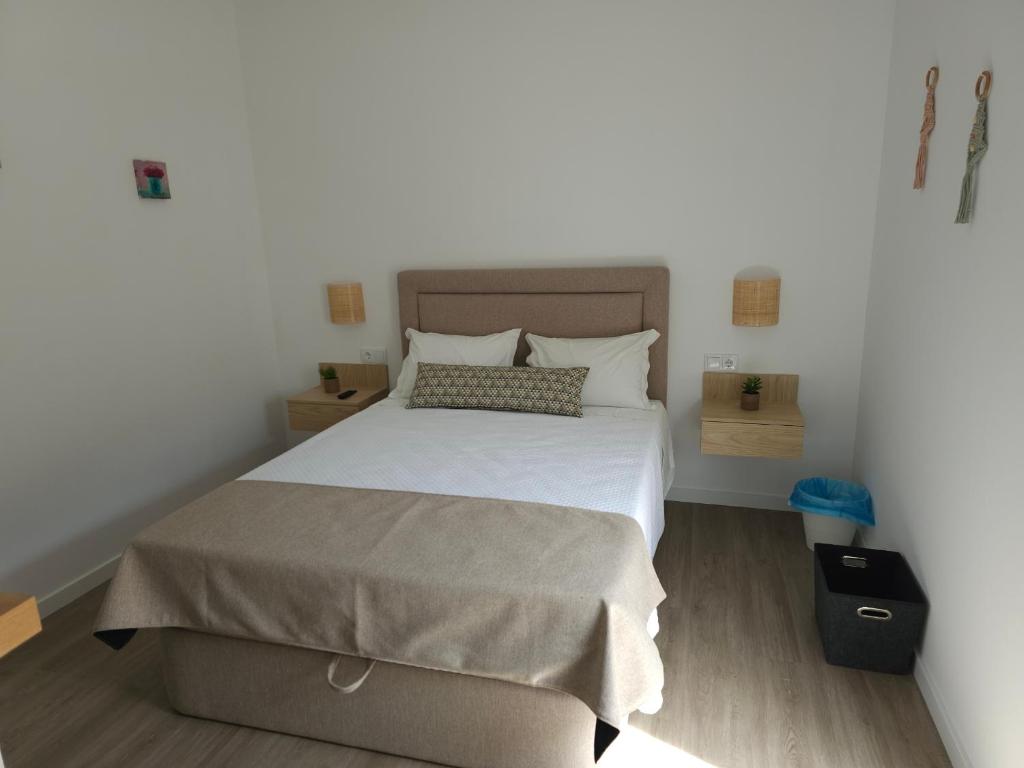 ein Schlafzimmer mit einem großen Bett mit weißer Bettwäsche in der Unterkunft Curtido House Suits - Suite in Ílhavo