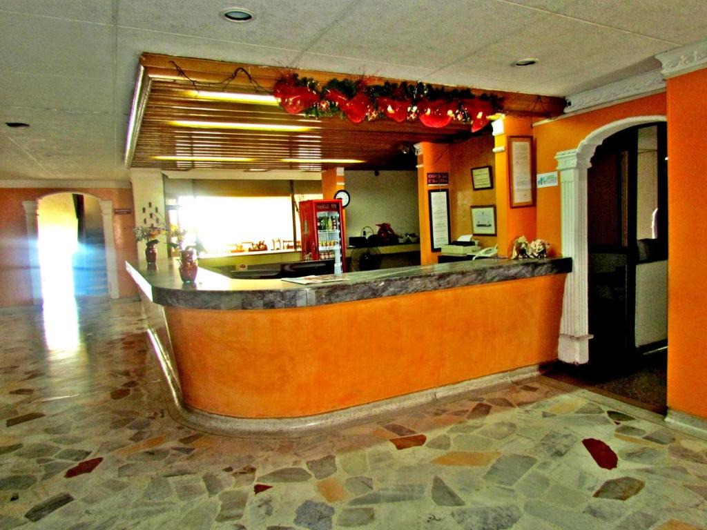 ネイバにあるHOTEL DINASTIA REAL NEIVAのオレンジ色の壁のレストランのバー