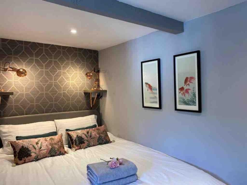 a bedroom with a white bed with two pictures on the wall at Jane's Pad in Bournemouth