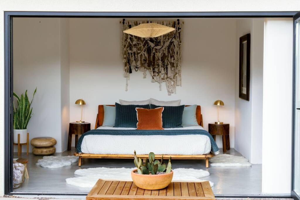 a bedroom with a bed and a table at Peaceful Desert Paradise - Casa Coyote in Joshua Tree