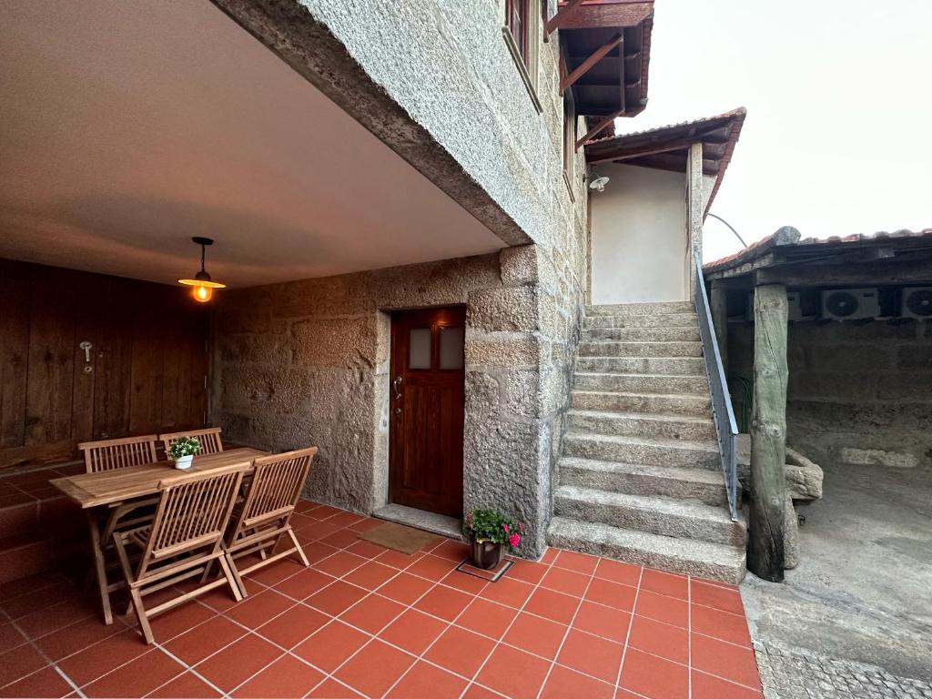 d'une terrasse avec une table, des chaises et des escaliers. dans l'établissement São Jorge Country House, à Penafiel
