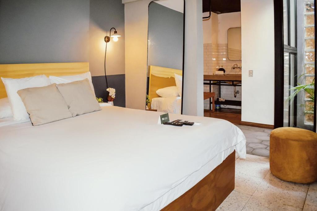 a bedroom with a large bed and a living room at Cardedeu Express Hotel in San Salvador