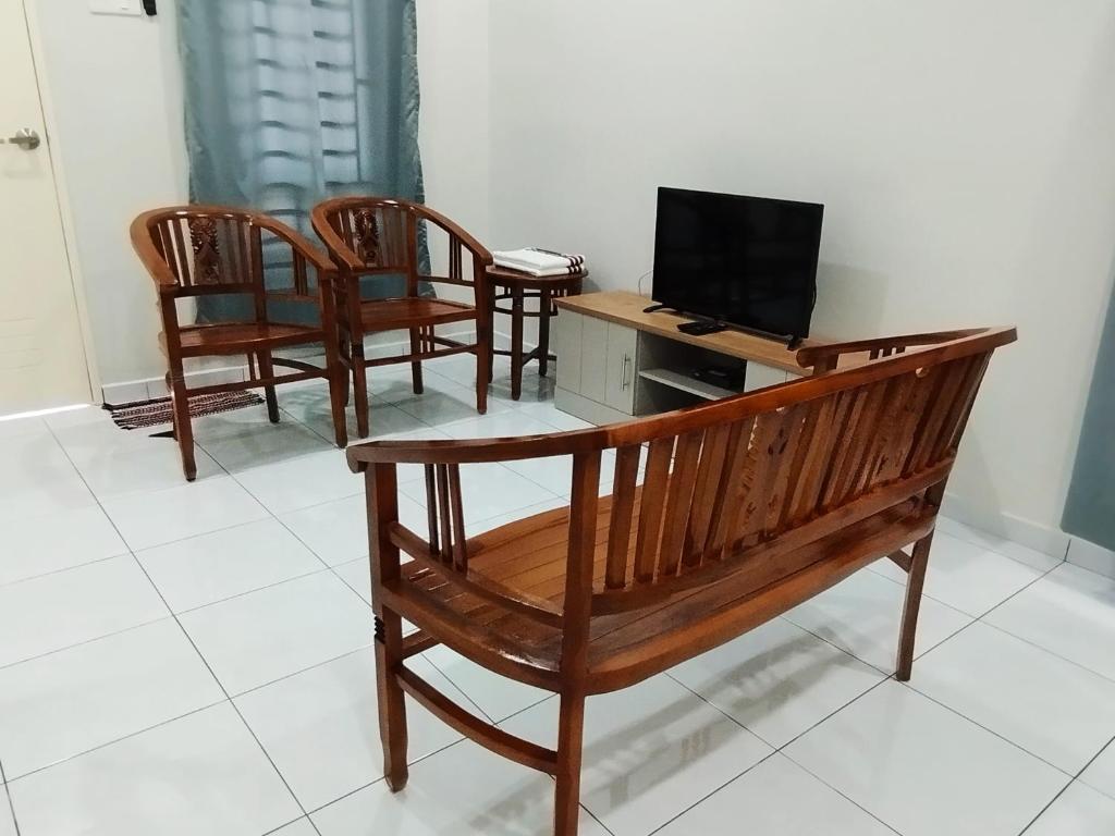 a room with four chairs and a bench with a laptop at Mukmin 2 Stay in Melaka