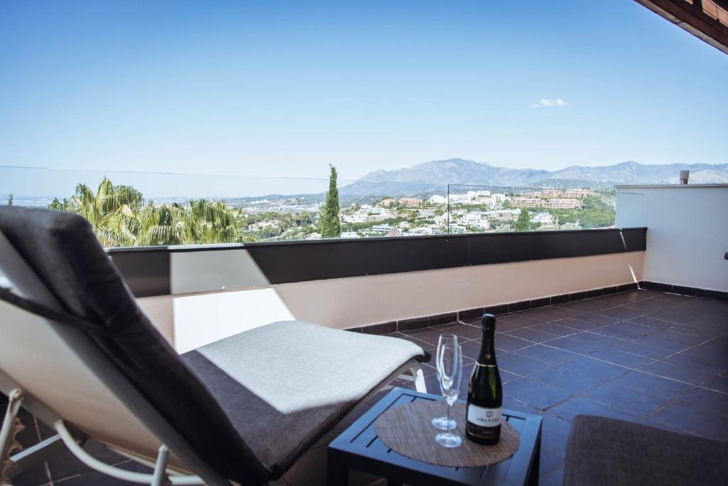 un balcón con una botella de vino en una mesa en Luxury apartment with panoramic views - Marbella, en Estepona