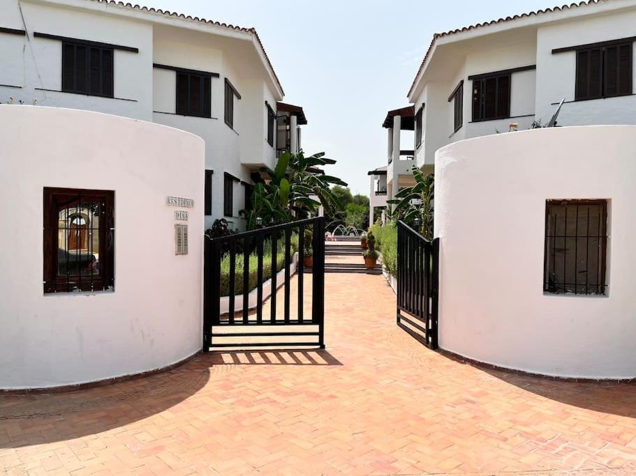 une porte noire devant deux bâtiments blancs dans l'établissement Appart magnifique Cabo Negro, à Cabo Negro