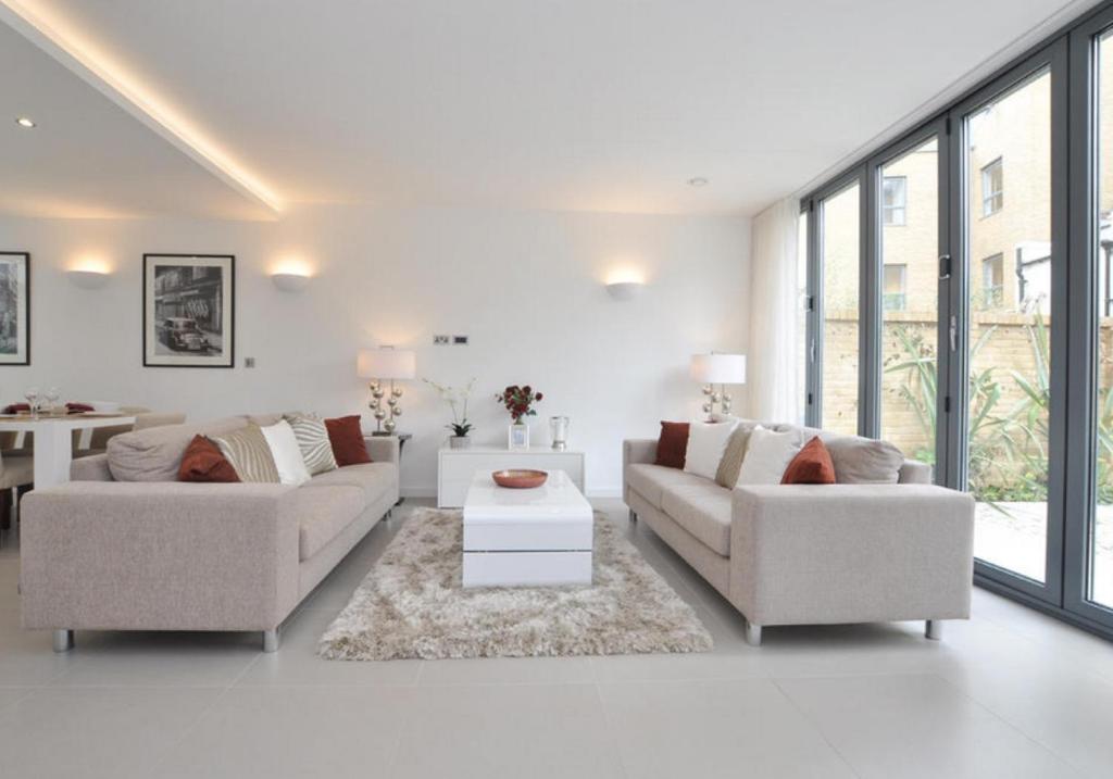 un soggiorno bianco con 2 divani e un tavolo di Luxury 4 bed home in Central London a Londra