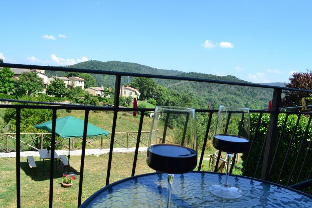 a glass table on a balcony with a view at Appartamento La Chiusa in Monticiano