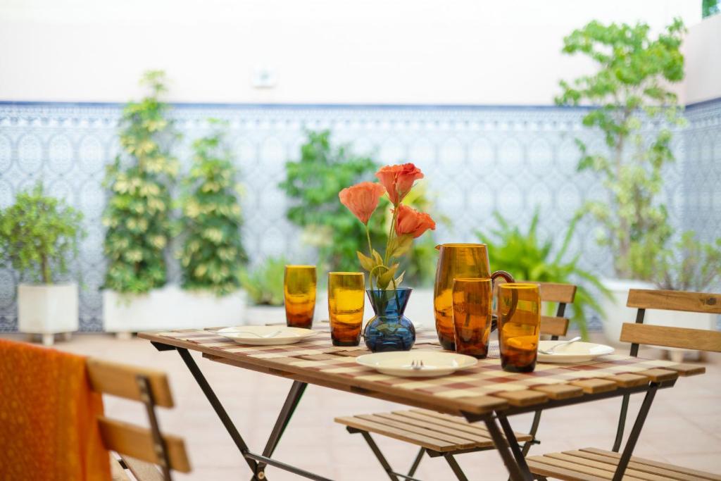 a table with glasses and a vase with a flower on it at Stars Courtyard by Fidalsa in Asprillas