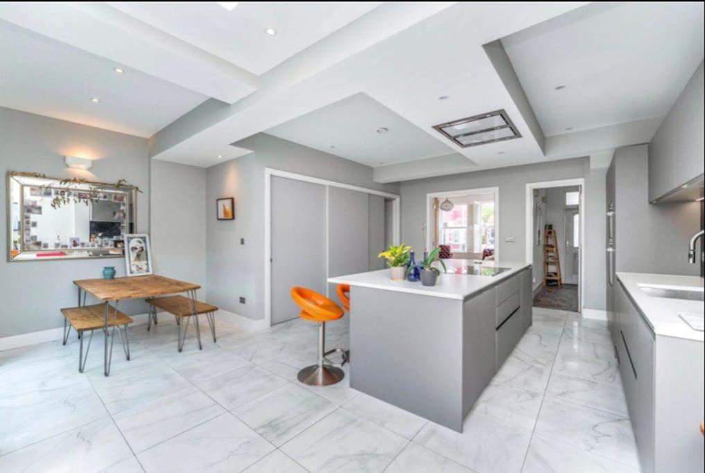 a kitchen and dining room with a table at Large, light & airy 4 bedroom home on quiet road in London