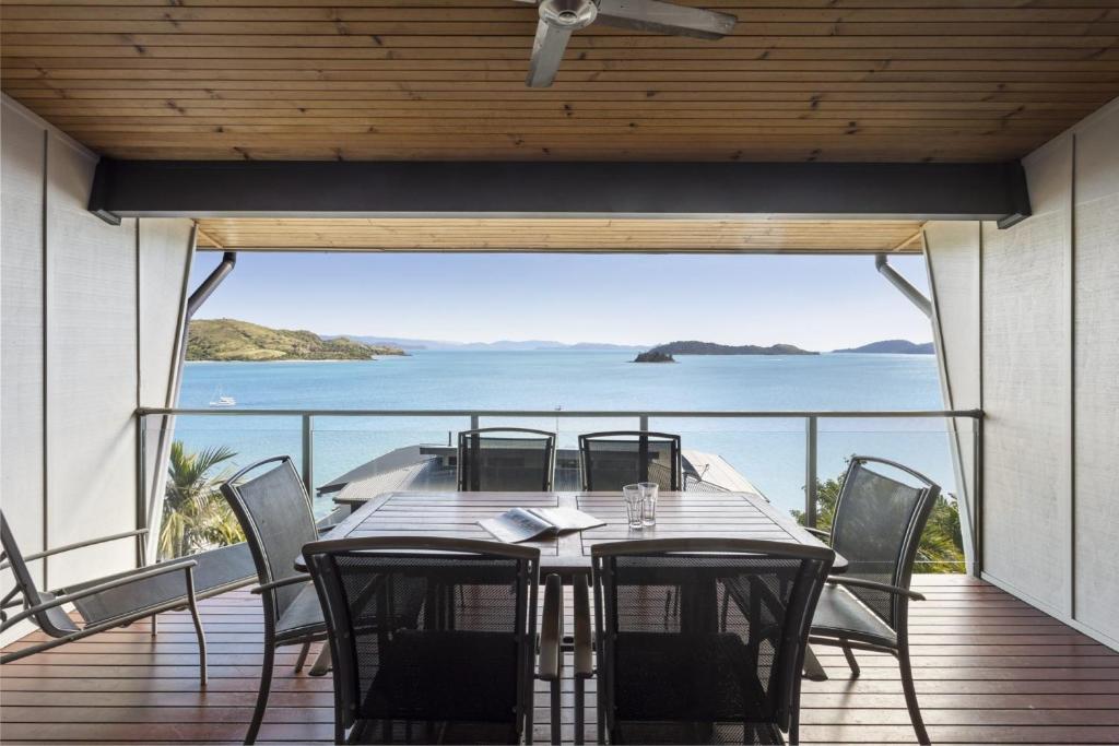 漢密爾頓島的住宿－Shorelines 27 Ocean View Buggy Transfers BBQ，海景甲板上的桌椅