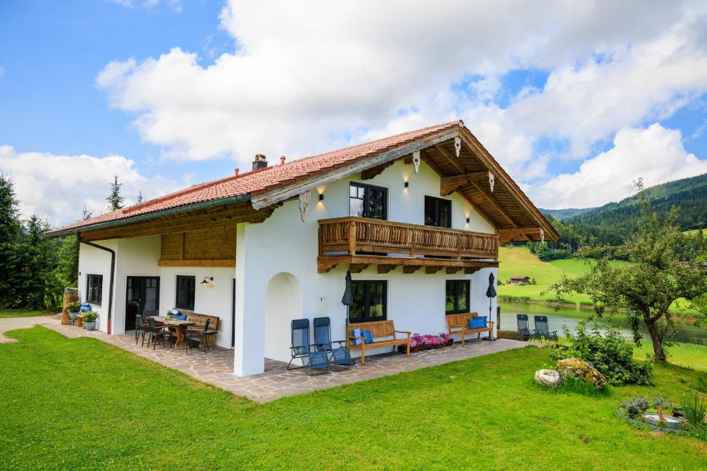 a house with a balcony and a yard at Ferienhaus Froschsee in Ruhpolding