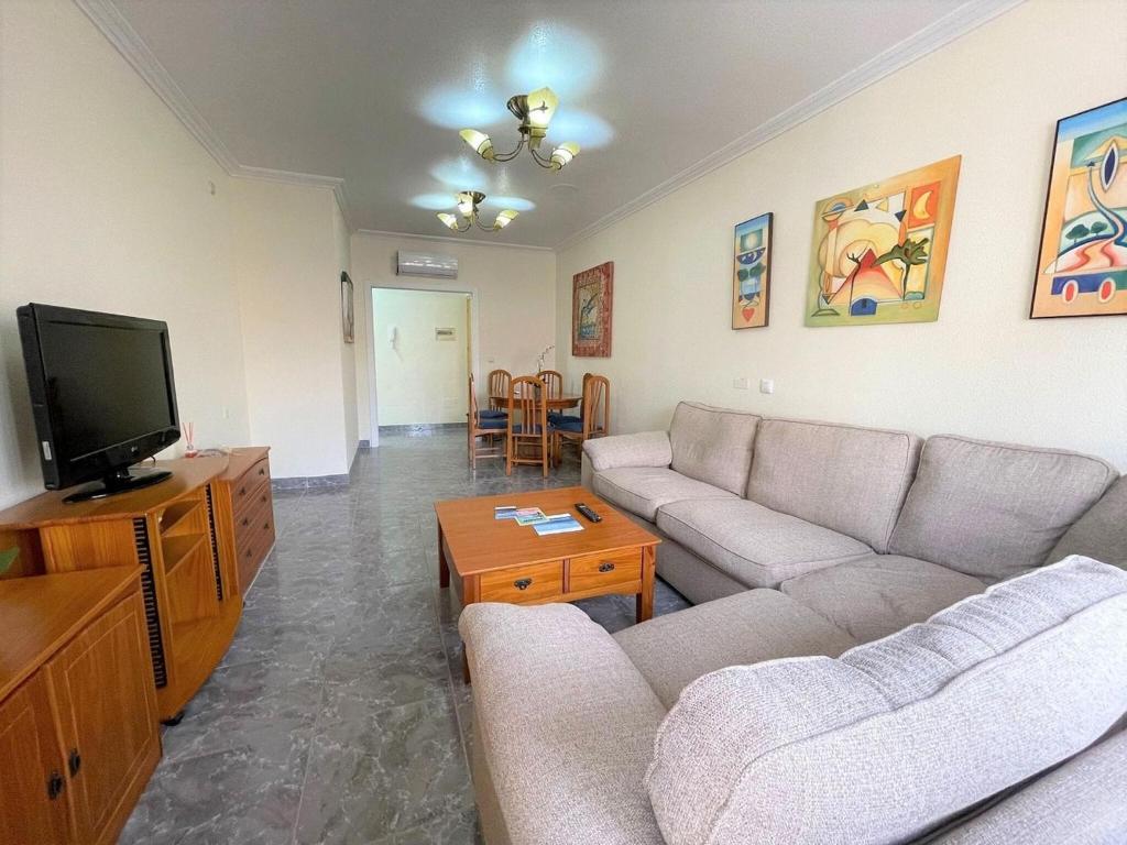 - un salon avec un canapé et une télévision dans l'établissement Spacious apartment in Los Alcazares with balcony, à Los Alcázares