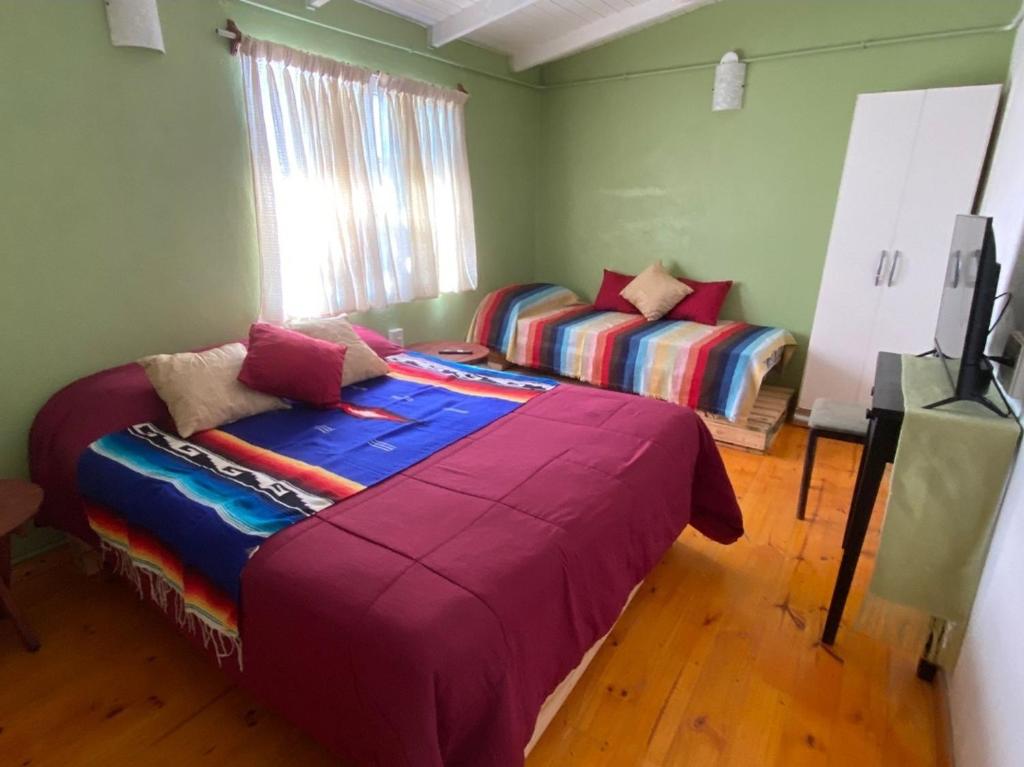 een slaapkamer met 2 bedden en een televisie. bij Mary's House in Puerto Iguazú