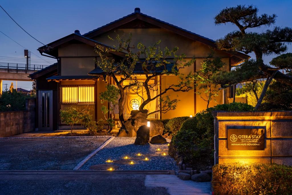 una casa con luces delante de ella en Temple Hotel 南アルプス法源寺 en Minami Alps