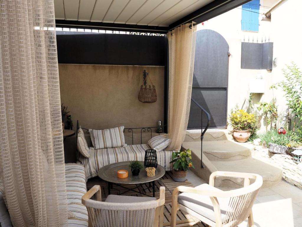 a patio with a couch and a table and chairs at Small holiday home with courtyard, Bellegarde in Bellegarde