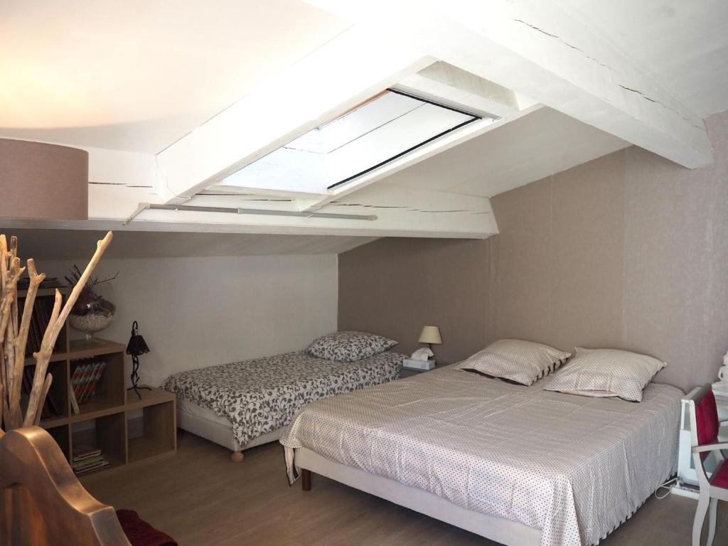 a bedroom with two beds and a skylight at Small holiday home with courtyard, Bellegarde in Bellegarde