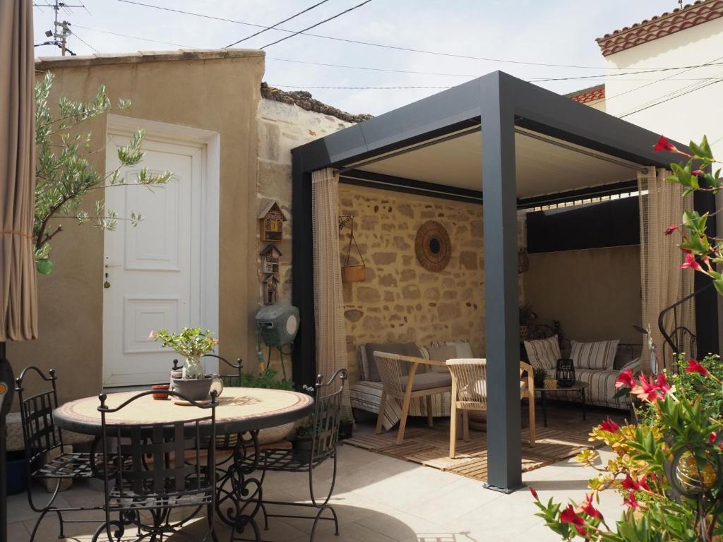 a patio with a table and chairs under a canopy at Small holiday home with courtyard, Bellegarde in Bellegarde